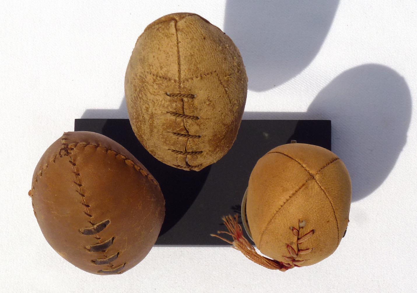 Three hand made miniature footballs